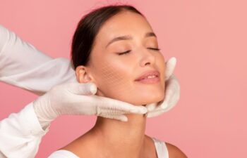 Skin Rejuvenation. Beautician Doctor Examining Face Of Beautiful Young Female With Drawn Mesh On Cheek, Attractive Woman Getting Beauty Treatments At Cosmetologist Cabinet, Pink Background, Collage