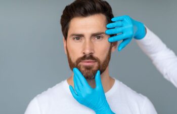 Plastic surgeon examining man's face