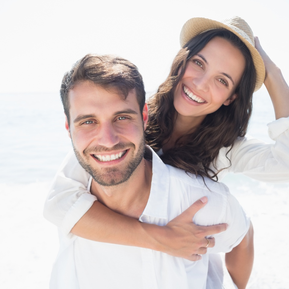happy couple smiling at the beach